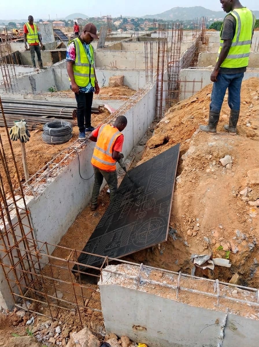 Foundation walls and starter bars at close range, with damp-proof membrane being placed before backfilling